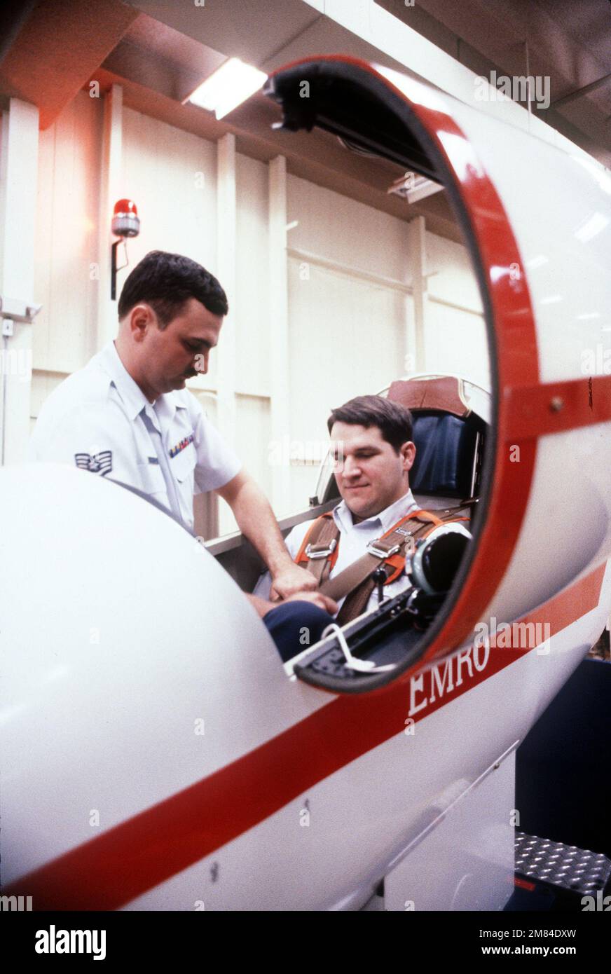 PERSONALE SGT. Glenn Hermes ispeziona l'imbracatura di un pilota prima di chiudere la tettoia di un allenatore di disorientamento spaziale negli Stati Uniti Air Force School of Aerospace Medicine. Base: Brooks Air Force base Stato: Texas (TX) Paese: Stati Uniti d'America (USA) Foto Stock