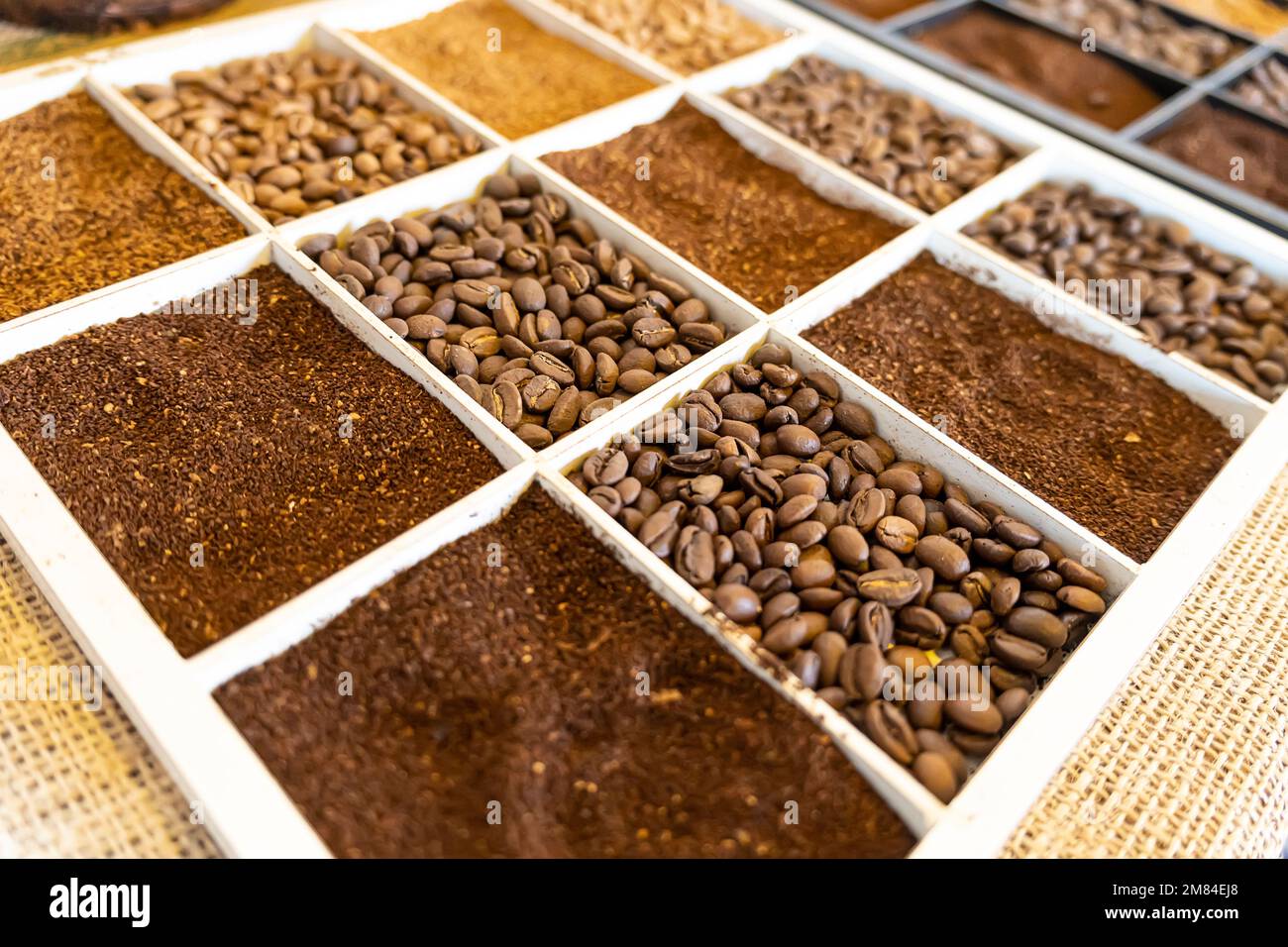 primo piano con chicchi di caffè. Vari tipi di caffè. grani interi e caffè macinato sul banco nel deposito. Foto Stock