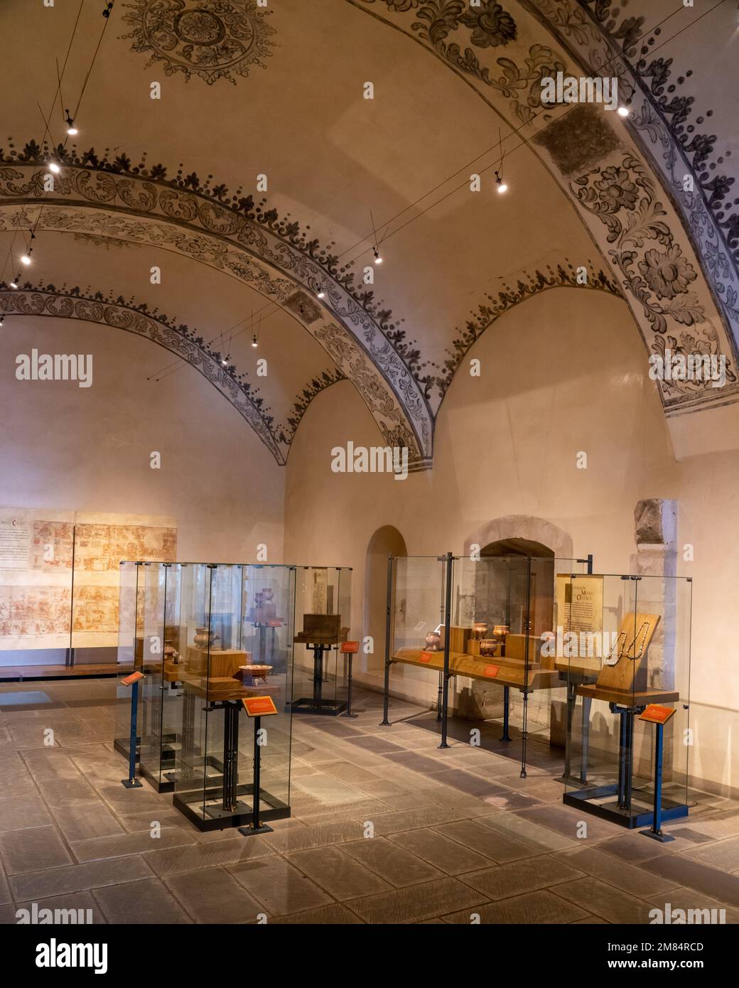 Una sala espositiva con mostre di manufatti pre-ispanici nel Museo della Cultura Oaxacan di Oaxaca, Messico. Si notano gli affreschi sul soffitto ad arco di Foto Stock