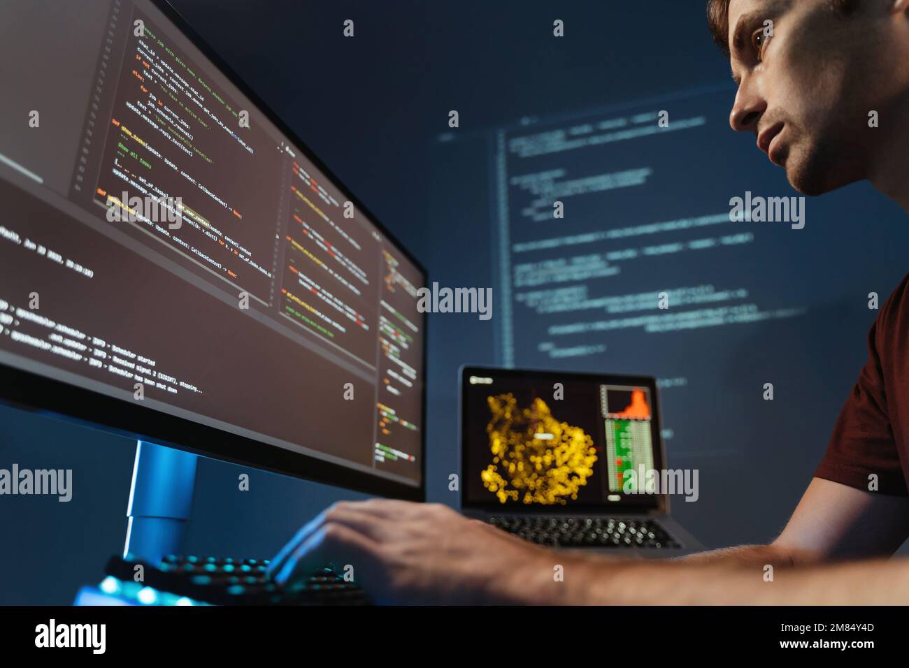 Primo piano di programmatori concentrati che lavorano sulla programmazione pc, la scrittura di codice per l'applicazione o la progettazione di siti web presso l'ufficio domestico per società di sviluppo software Foto Stock