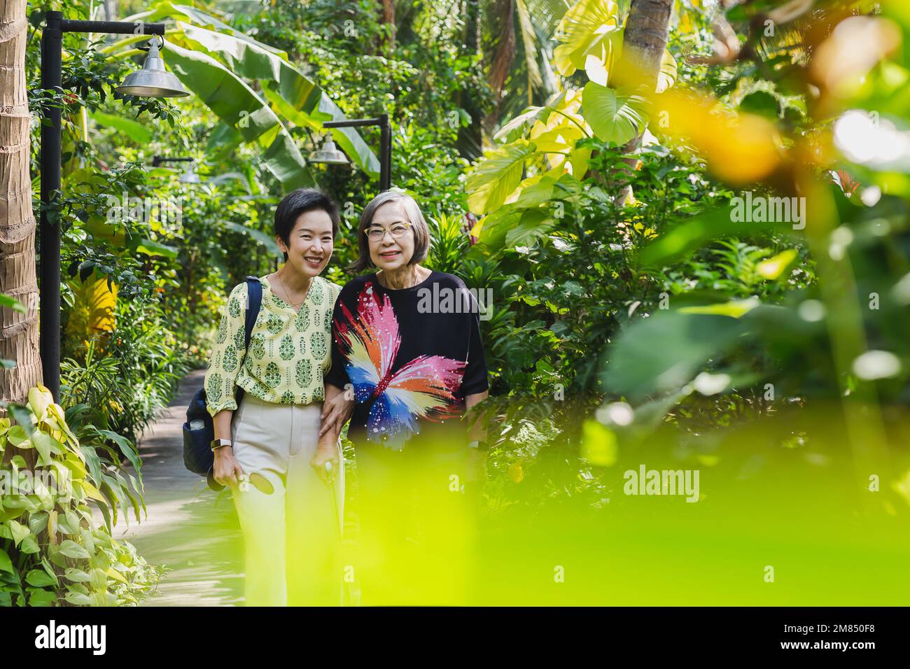 Madre e figlia senior sorridenti in piedi in giardino in vacanza. Foto Stock