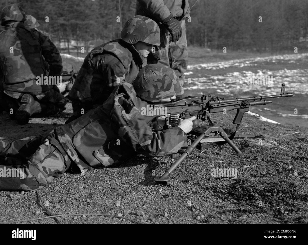 Un midshipman della Marina ROTC spara un machinegun leggero M-60 sulla gamma durante l'addestramento alla scuola di base come un istruttore osserva la tecnica. Base: Marine Corps base, Quantico Stato: Virginia (VA) Paese: Stati Uniti d'America (USA) Foto Stock