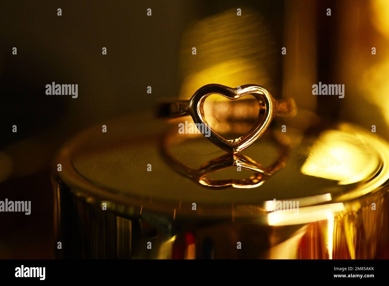 Un primo piano di un anello a forma di cuore per la proposta sul comò Foto Stock