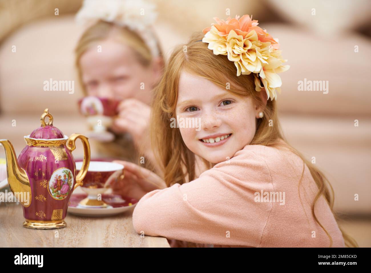 Godendo una festa del tè con la sua amica. Un giovane rosso carino che si diverte con un tè con la sua amica. Foto Stock