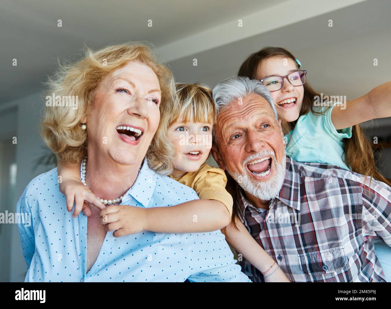 nipote famiglia figlio nonno uomo donna nonno felice insieme nonna ragazza anziano ragazzo sorridente nonna piggyback Foto Stock
