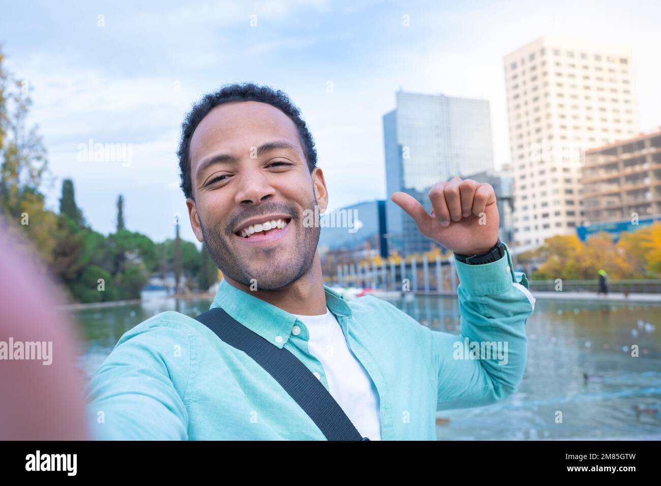 Giovane afro-americano che prende un selfie guardando la fotocamera sorridente - studente turistico Foto Stock