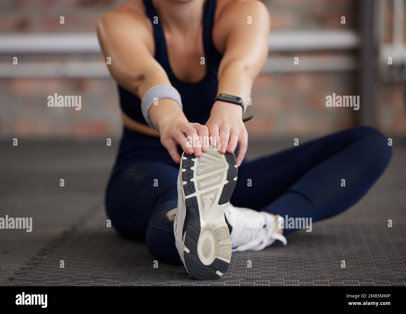 Donna, gambe e stretching in palestra fitness per allenamento, allenamento e esercizio di dolore muscolare, rilascio di tensione e benessere del corpo. Atleta sportivo Foto Stock