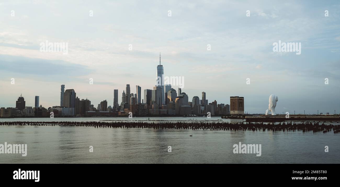 Una bella vista di un World Trade Center a New York City con un mare calmo sotto un cielo nuvoloso Foto Stock