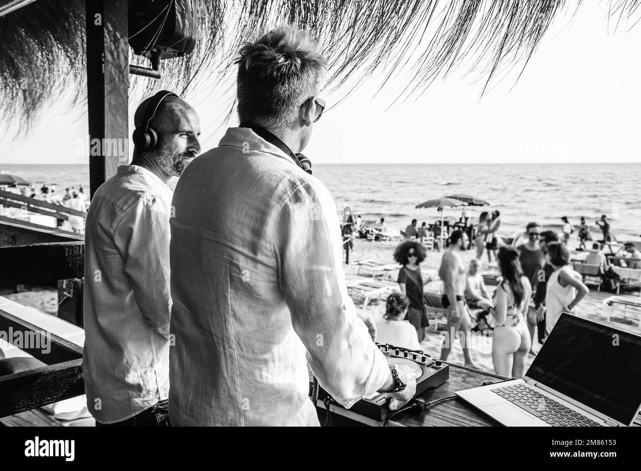 Disc jockeys che suona musica per i turisti al club party all'aperto sulla spiaggia - DJ indossando le cuffie all'evento musicale dal vivo - Musica e concetto di divertimento Foto Stock