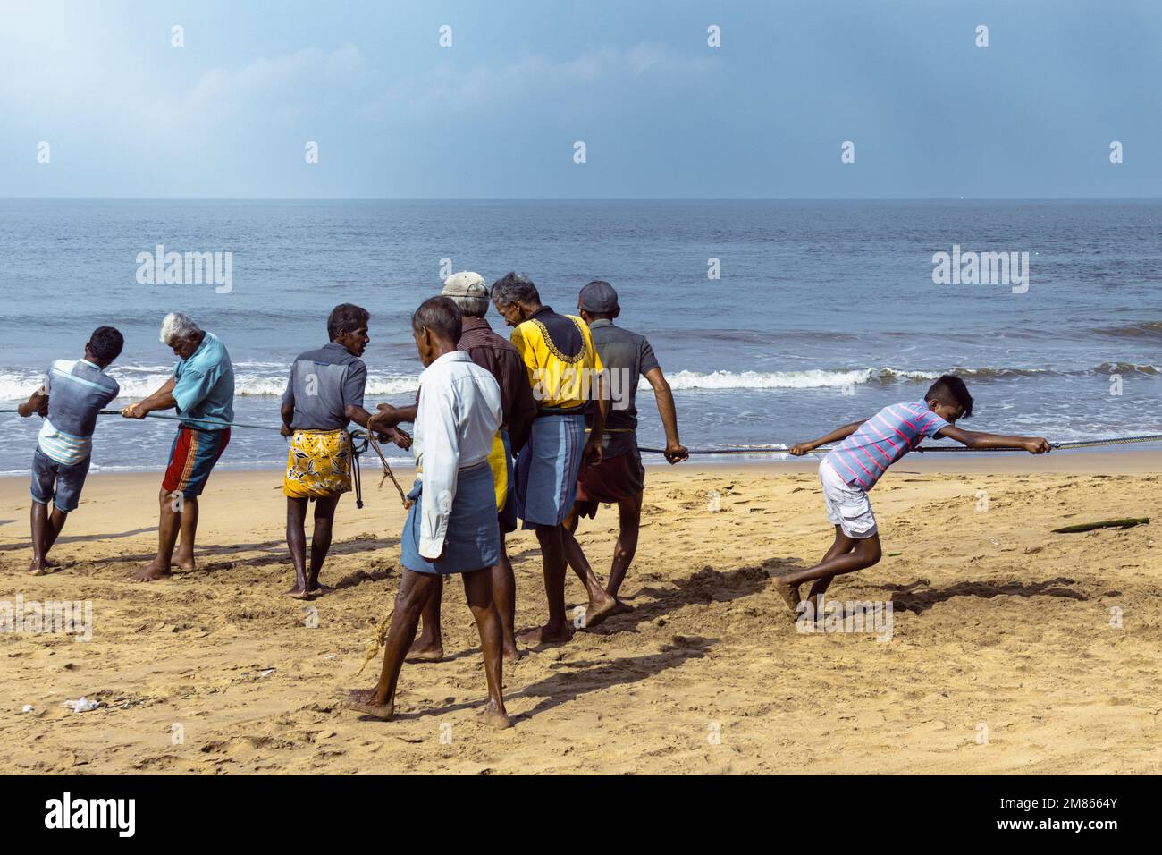 I pescatori tirano le loro reti sulla spiaggia. Foto Stock