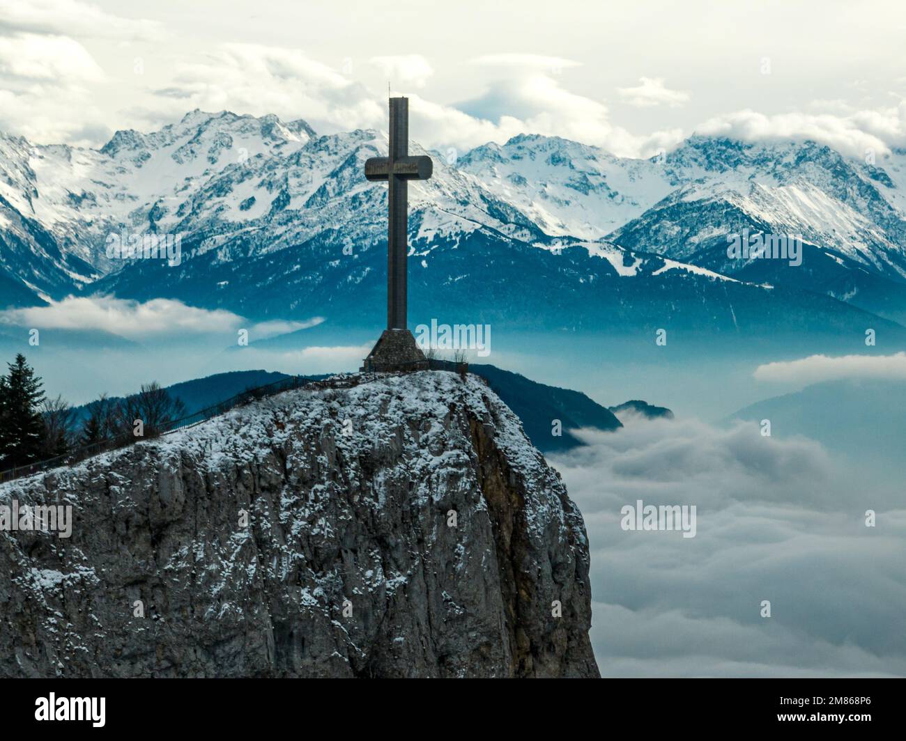 Prospettiva droni della croce di legno Croix du Nivolet ai margini della Dent du Nivolet, nel massiccio di Bauges, con la catena montuosa delle alpi innevate alle spalle Foto Stock