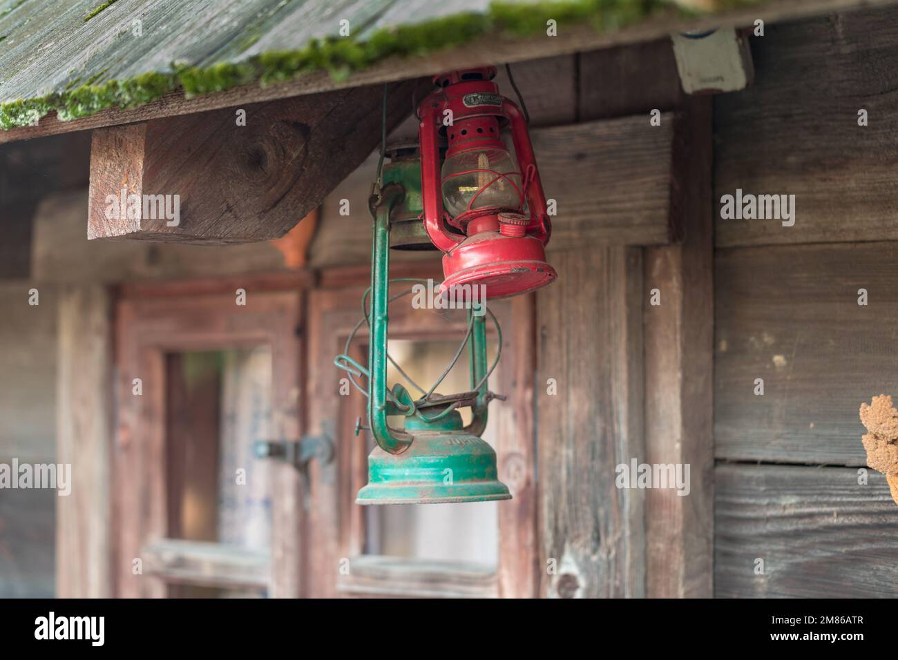 Una vecchia lampada a cherosene appesa ad una trave o finestra di legno. Foto Stock