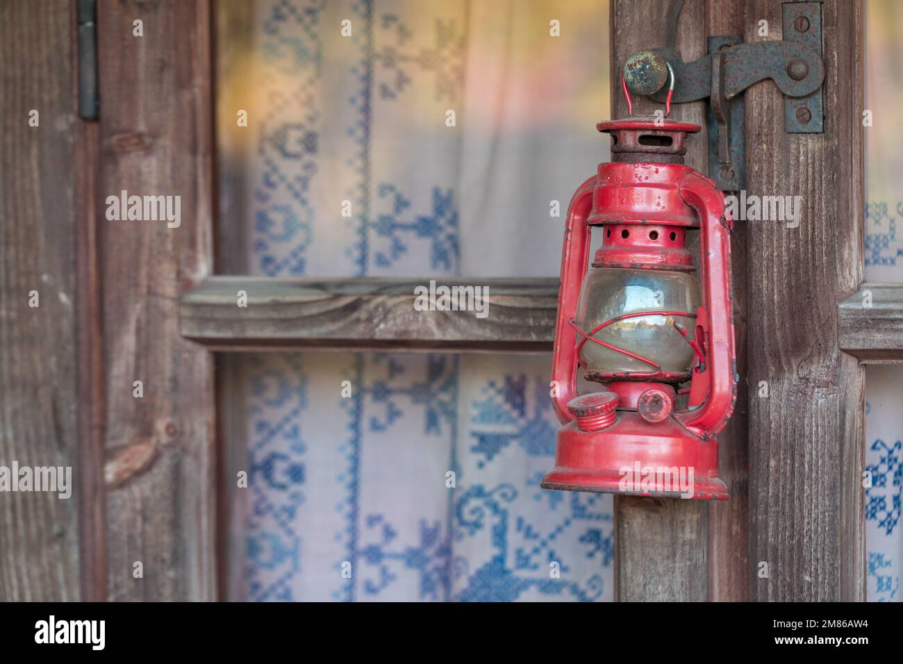 Una vecchia lampada a cherosene appesa ad una trave o finestra di legno. Foto Stock