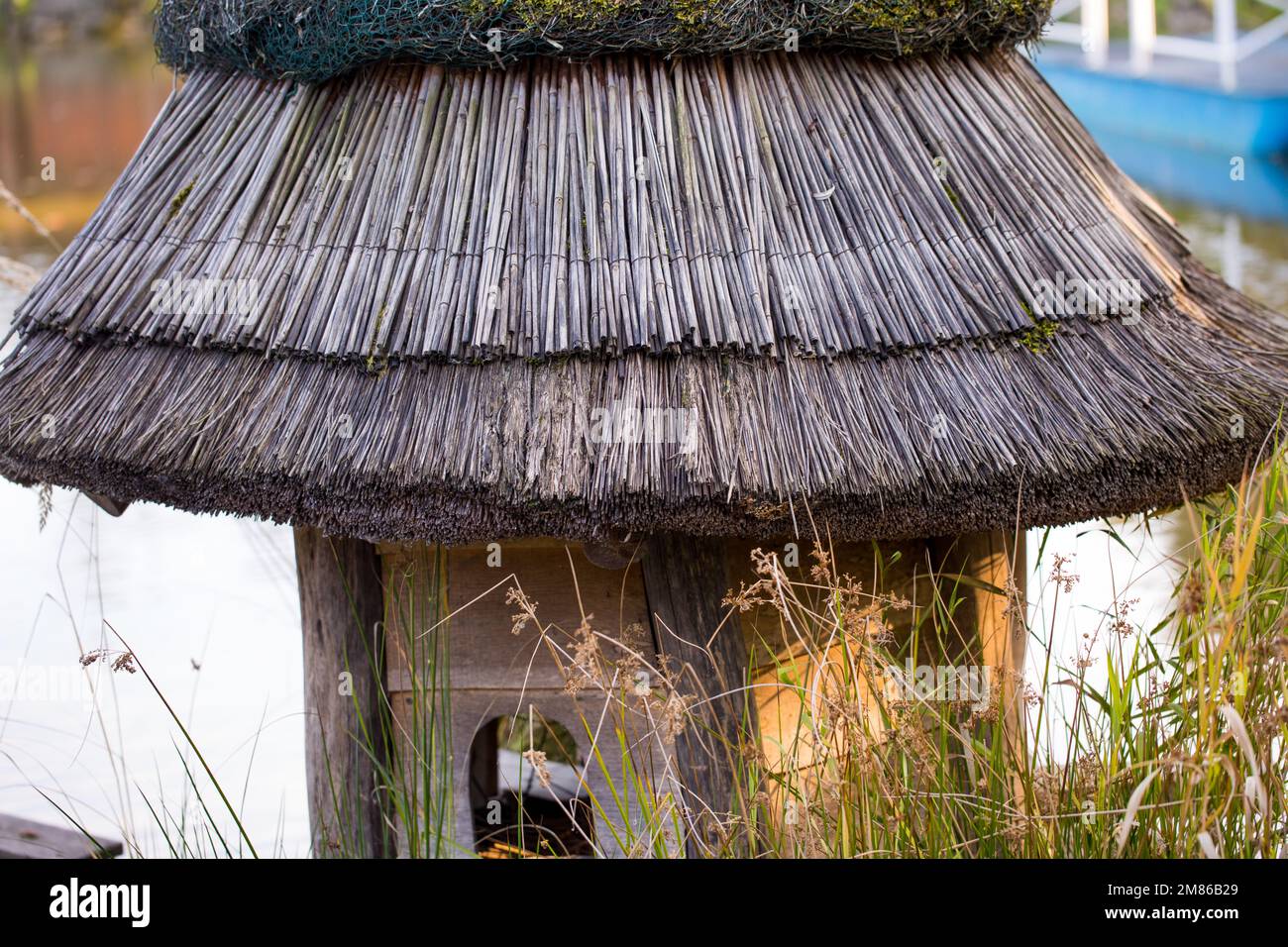 Birdhouse in legno sull'acqua, tetto in paglia. Foto Stock