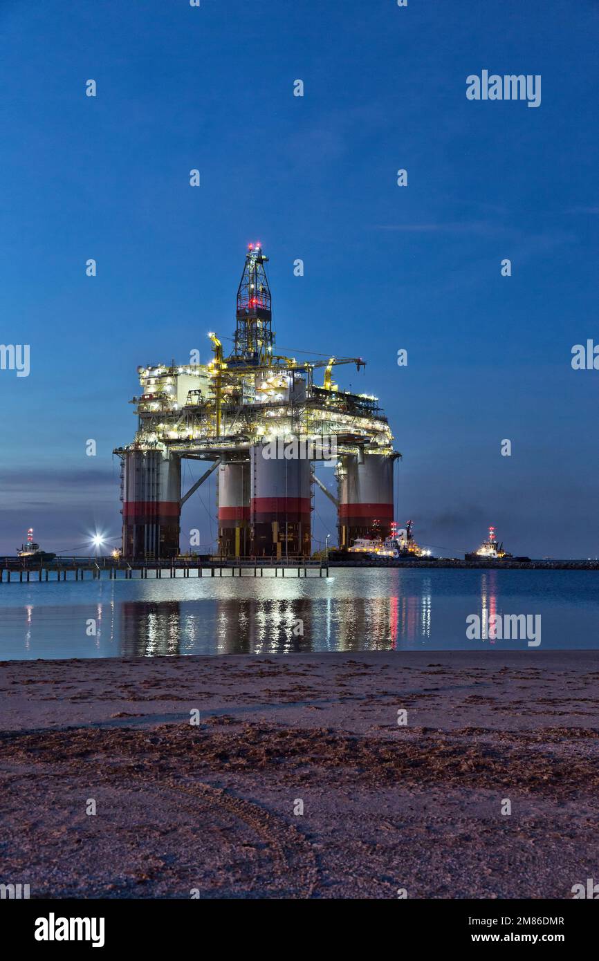 Piattaforma 'Big Foot' Chevrons Deep Ocean, piattaforma di estensione gamba, rimorchiatori che assistono, partenza a mezzanotte da Ingleside Bay, Kiewit Industries, Texas. Foto Stock