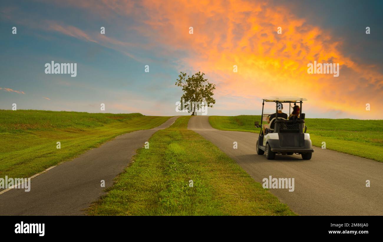 Chiang Rai, Thailandia. Novembre 18, 2022. Golf cart in movimento in uno splendido parco di Singha. Guida su strade rurali al tramonto, sfocatura del movimento. Foto Stock