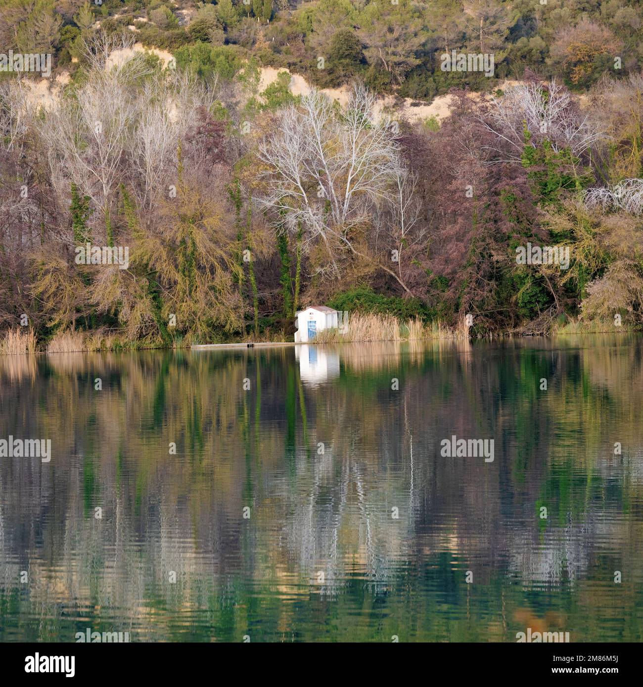 Casa di pesca si riflette con la foresta che la circonda nel lago Banyoles, Catalogna, Spagna Foto Stock