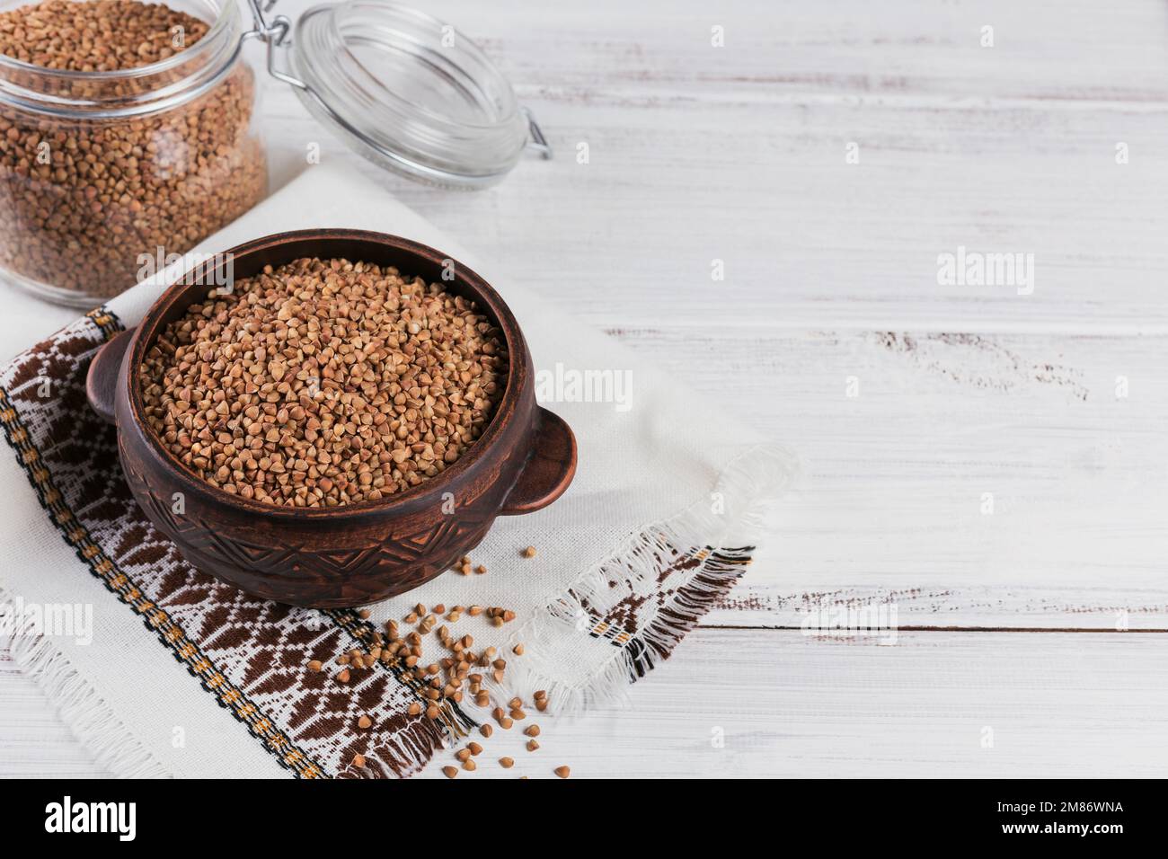 Primo piano dei semini di grano saraceno. Grani di grano saraceno crudo come texture di fondo. Foto Stock