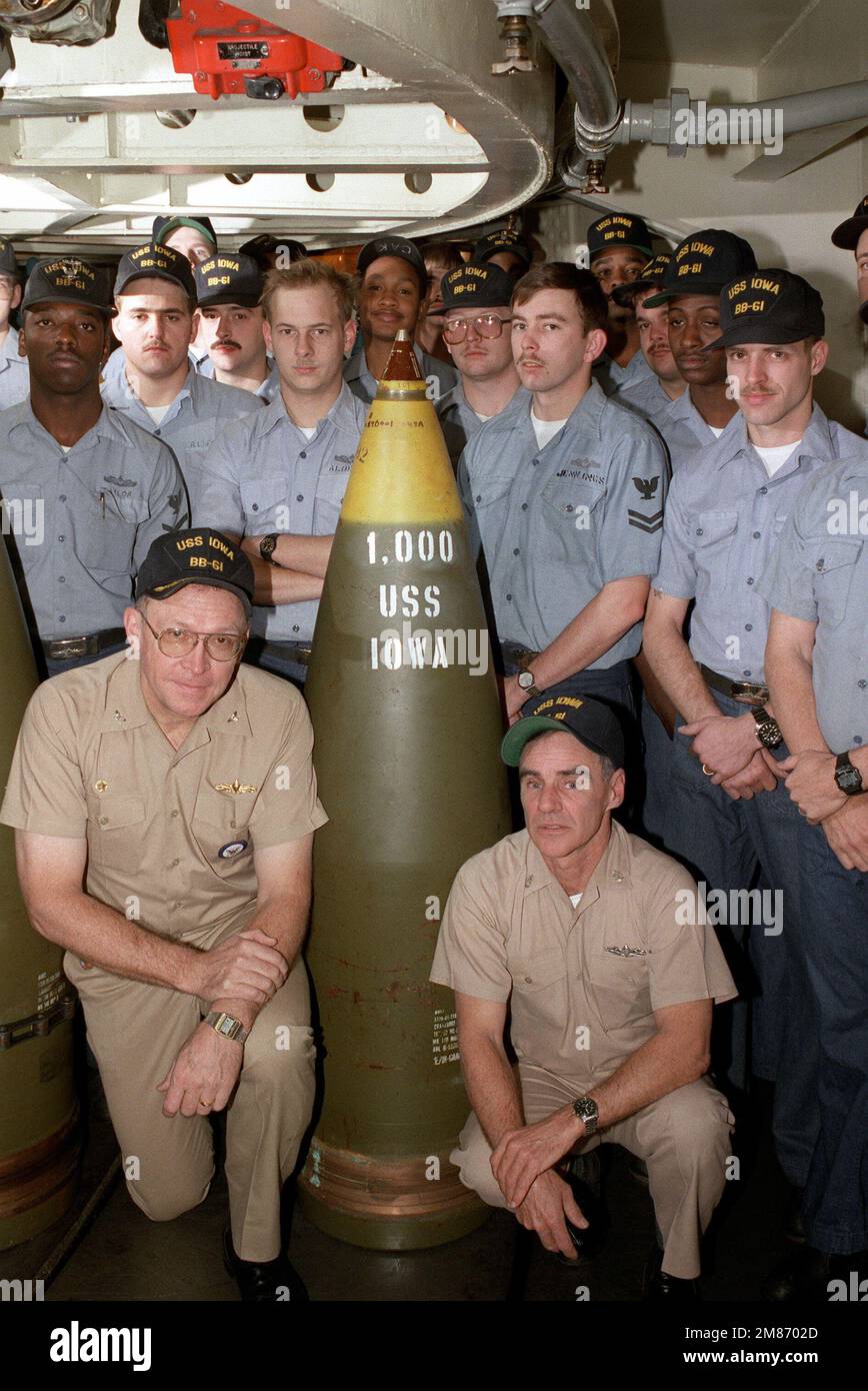 Il capitano Larry Seaquist, ufficiale comandante della nave da guerra USS IOWA (BB-61), a sinistra, si pone con i membri di un equipaggio di armi e il tondo di 00th 16 pollici/50 pollici che sarà sparato dall'IOWA dopo i processi in mare nel marzo 1985. Paese: Sconosciuto Foto Stock