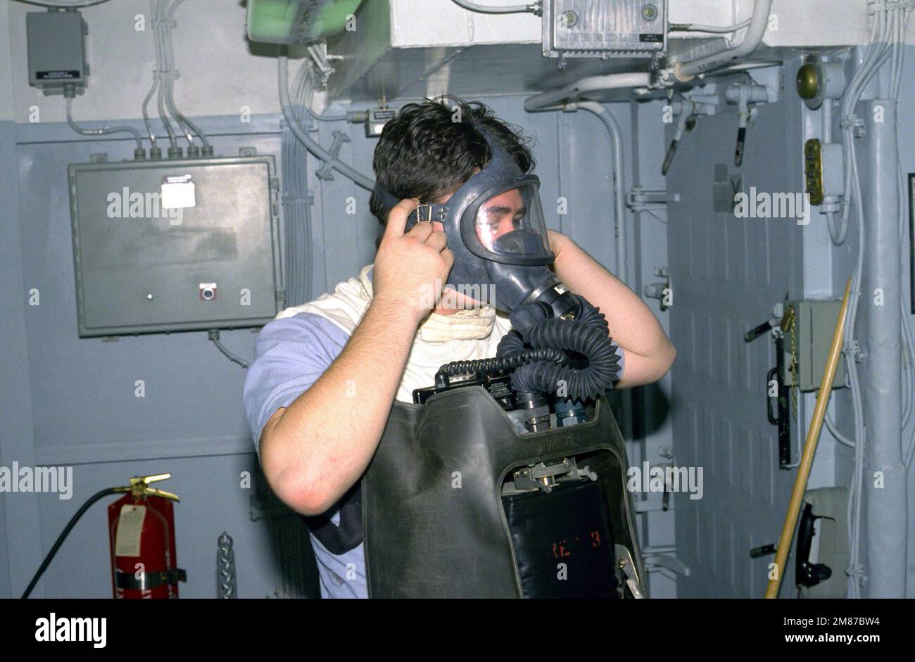 Un marinaio controlla il sigillo sulla maschera del suo apparecchio di respirazione ad ossigeno (OBA) durante un'esercitazione generale a bordo della portaerei a energia nucleare USS THEODORE ROOSEVELT (CVN-71). Paese: Sconosciuto Foto Stock