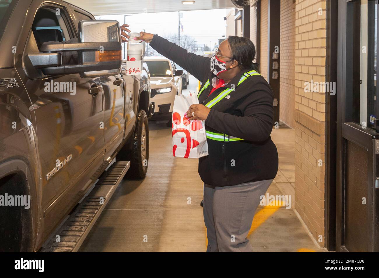Livonia, Michigan - Un lavoratore di Chick-fil-A consegna un drive-through ordine il giorno della grande apertura del ristorante. Foto Stock