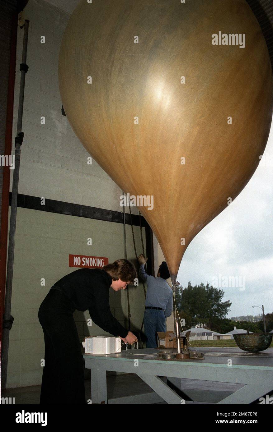 Presso la Naval Oceanographic Command Facility, il loggett di classe Mate 3rd dell'aerografo prepara una radiosonde per il lancio per raccogliere informazioni meteorologiche. Base: Aeronavale, Bermuda Nazione: Bermuda (BMU) Foto Stock