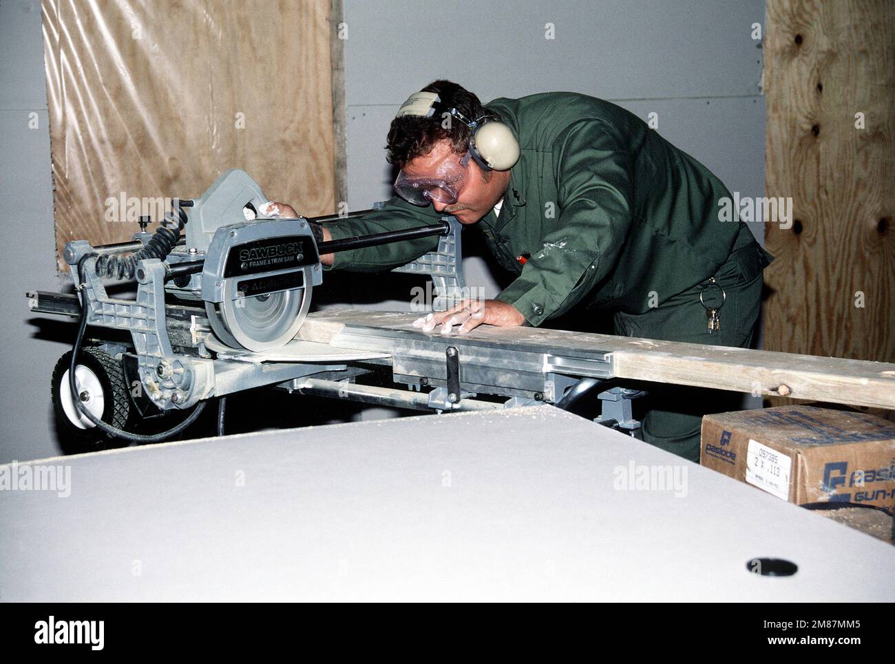 Un costruttore dell'unità di battaglione di costruzione 412 (CBU-412) taglia il legno per fare un telaio della finestra per il randello di distacco della marina. Base: Naval Weapons Station Charleston Stato: South Carolina (SC) Paese: Stati Uniti d'America (USA) Foto Stock