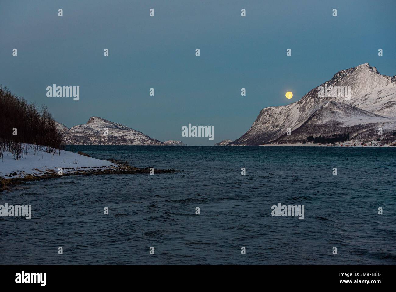 Notte polare e luna piena nel paesaggio artico vicino Tromso, Norvegia Foto Stock