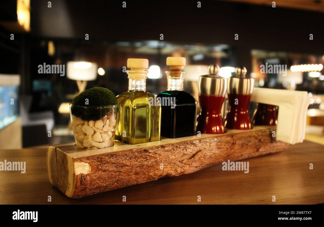 Bottiglie in vetro con agitatori per olio, aceto, sale e pepe su Un tavolo Foto Stock