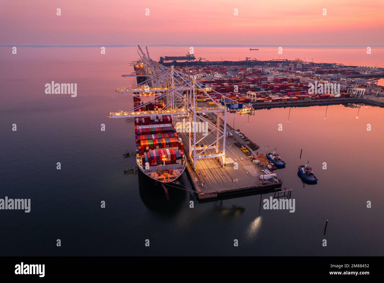 Terminale di carico che carica i contenitori di spedizione sulle navi da carico, riprese aeree, iperlapse, Vancouver, BC, Canada, terminal marittimo, gru da carico. Foto Stock