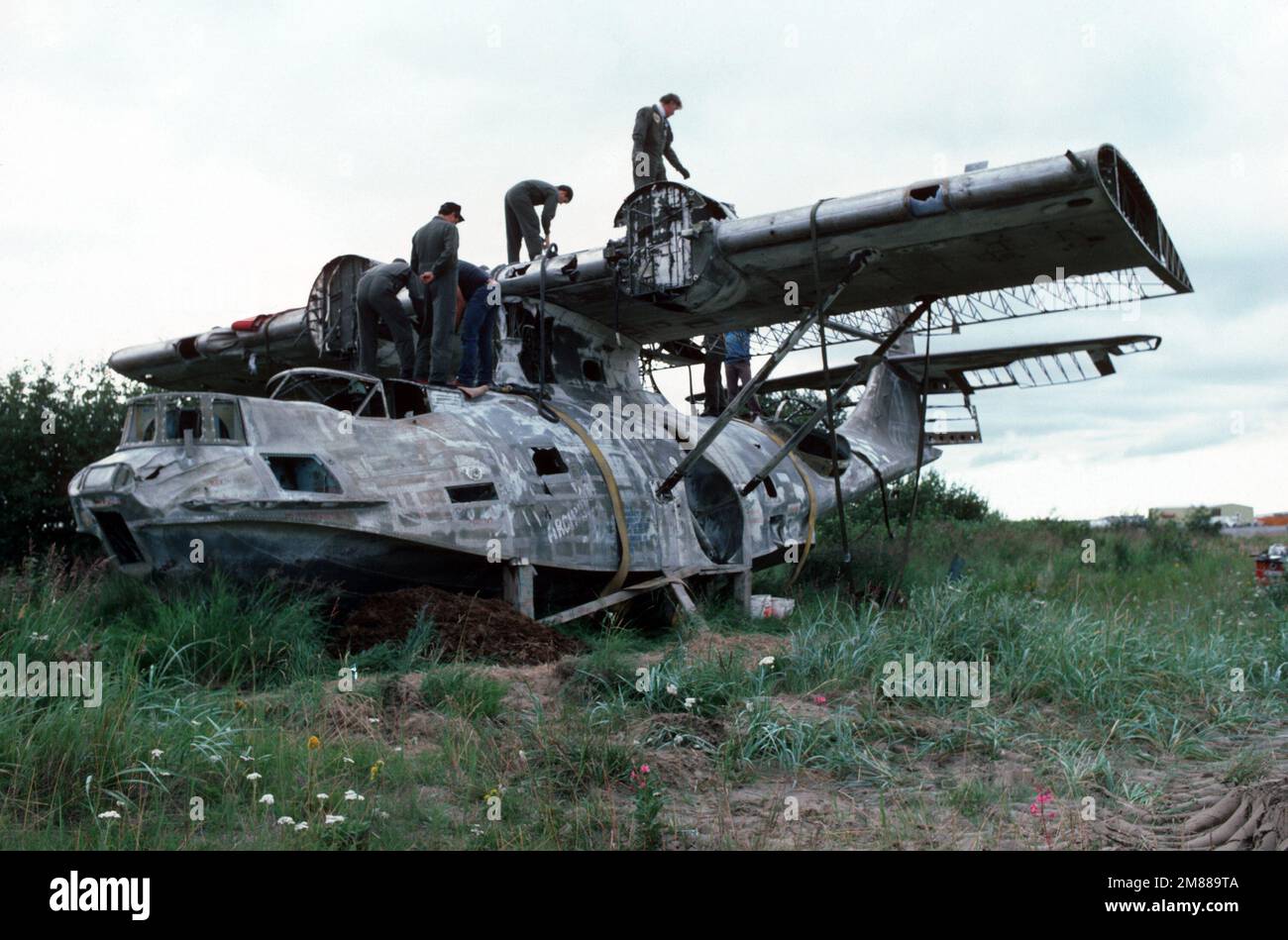 I membri della Guardia Nazionale dell'Armata dell'Alaska e dell'Alaska Aviation Heritage Museum (AAHM) montano un'imbarcazione volante della PBY Catalina OA-10 per il sollevamento aereo da un CH-54B Tahre durante un'operazione di recupero iniziata dall'AAHM. L'aereo storico fu abbandonato dall'Aeronautica militare dopo che i problemi del motore lo costringevano a scendere al Lago di Dago il 30 settembre 1947. I membri dell'AAHM hanno in programma di ripristinare l'aereo e di farlo volare di nuovo nei primi anni '1990s. Paese: Stati Uniti d'America (USA) Foto Stock