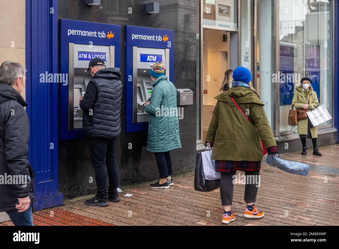 Persone che utilizzano ATM TSB permanenti a Patrick Street, Cork, Irlanda. Foto Stock