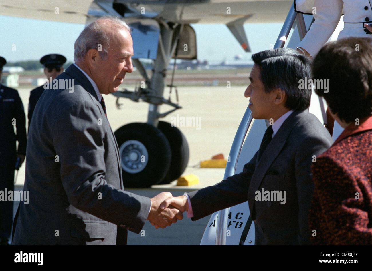 Il Segretario di Stato George P. Schultz saluta Price Akihito all'arrivo del dignitario per una visita di Stato. Base: Andrews Air Force base Stato: Maryland (MD) Paese: Stati Uniti d'America (USA) Foto Stock