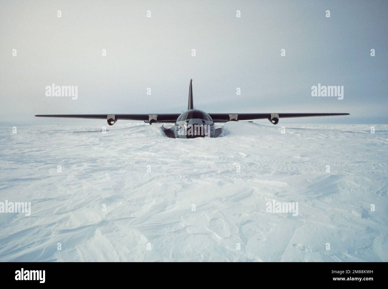 Una vista frontale di un aeromobile LC-130 Hercules, sepolto nella neve dal suo incidente nel 1971, con navicelle motore vuote. Nel gennaio 1987 il proprietario dell'aereo, la National Science Foundation, ha determinato che sarebbe stato meno costoso riparare l'imbarcazione che acquistarne una nuova. Tutti e quattro i motori sono stati sostituiti, e l'aereo è stato volato dal sito di incidente un anno più tardi. Paese: Antartide (ATA) Foto Stock