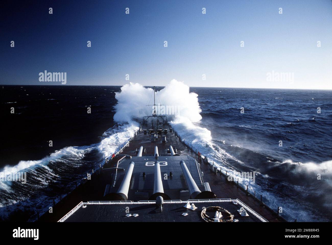 Una vista dei cannoni Mark 7 16 pollici calibro 50 delle torrette n° 1 e 2 a bordo della nave da guerra USS MISSOURI (BB-63) come onde rompere sopra l'arco della nave in mari accidentati. Paese: Oceano Pacifico (POC) Foto Stock