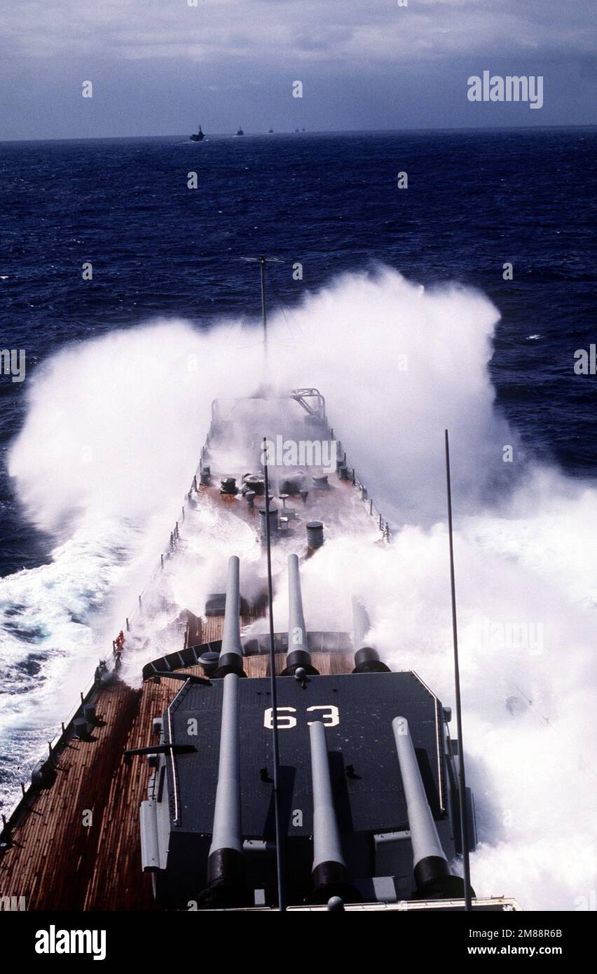 Una vista dei cannoni Mark 7 16 pollici calibro 50 delle torrette n° 1 e 2 a bordo della nave da guerra USS MISSOURI (BB-63) come onde rompere sopra l'arco della nave in mari accidentati. Paese: Oceano Pacifico (POC) Foto Stock