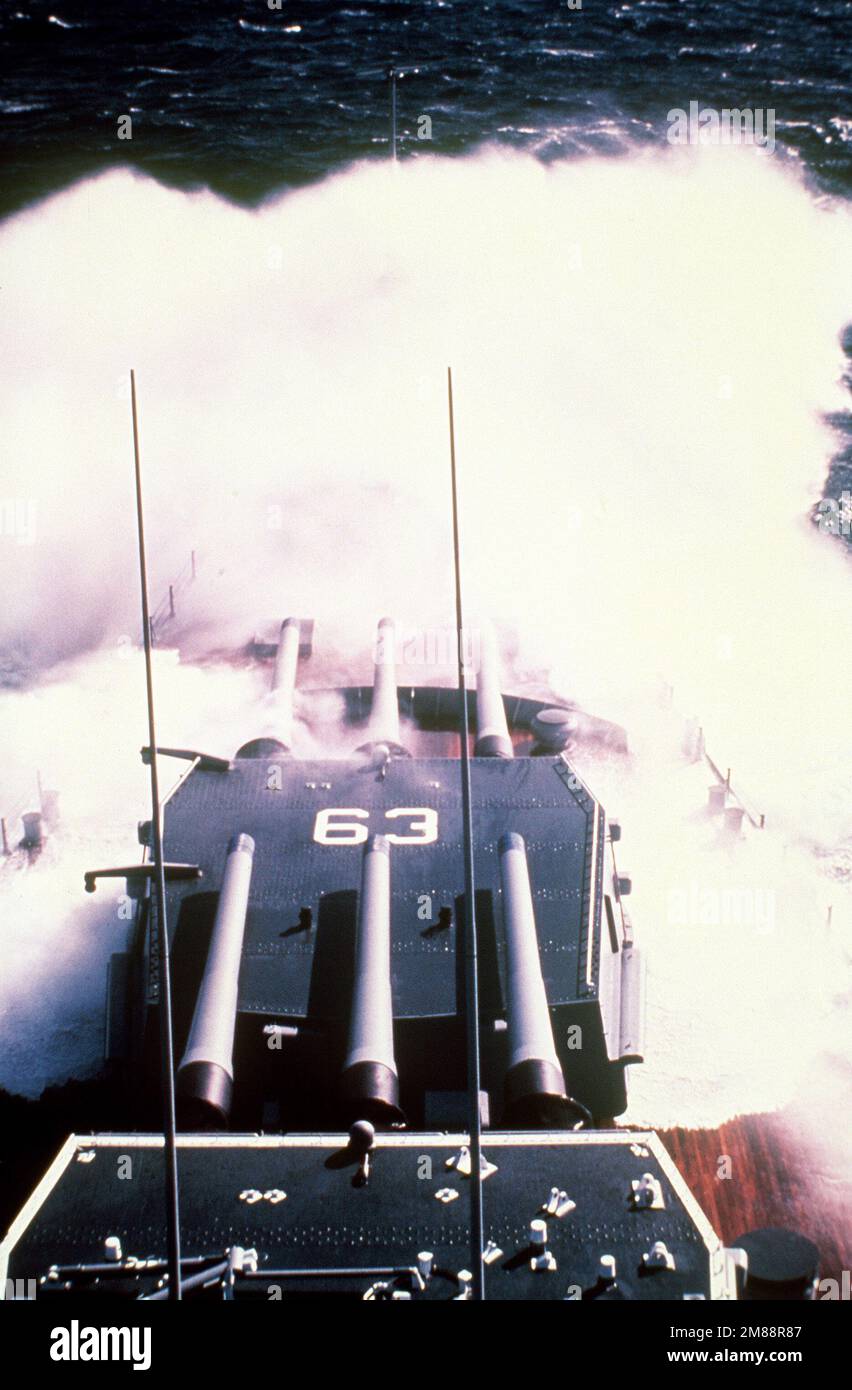 Una vista dei cannoni Mark 7 16 pollici calibro 50 delle torrette n° 1 e 2 a bordo della nave da guerra USS MISSOURI (BB-63) come onde rompere sopra l'arco della nave in mari accidentati. Paese: Oceano Pacifico (POC) Foto Stock