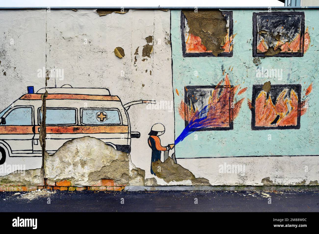 Pittura infantile su muro in decadenza, i vigili del fuoco spengono casa bruciante, Kempten, Allgaeu, Baviera, Germania Foto Stock