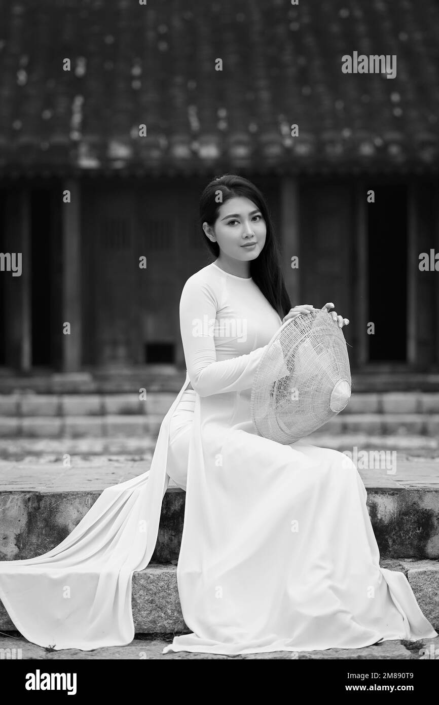 Ho Chi Minh città, Viet Nam: Ao dai è vestito tradizionale del vietnam, bella donna vietnamita in bianco Ao dai vestito nel parco Foto Stock