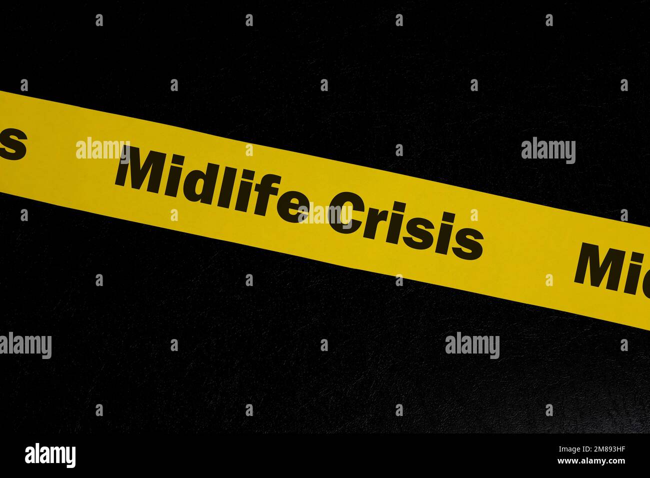 Concetto di cautela e avvertimento per la crisi di mezza età. Nastro di barricata giallo con parola crisi midlife su sfondo nero scuro. Foto Stock