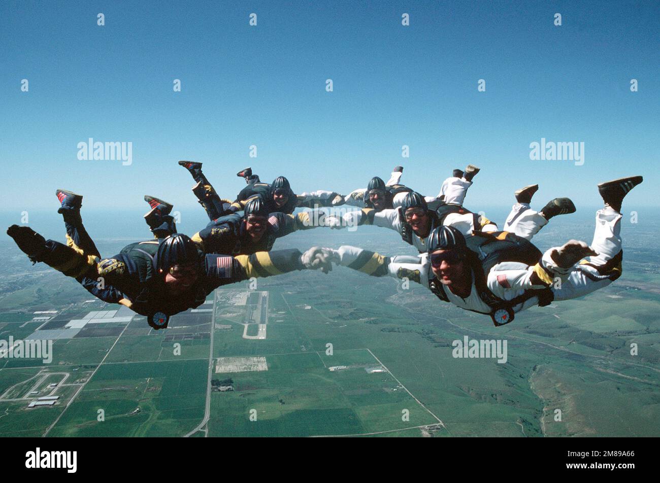 Sei membri della squadra di paracadute della Marina si uniscono per scattare una foto di gruppo durante una discesa in caduta libera. Il team, un'unità del comando Naval Special Warfare, si esibisce in occasione di eventi in tutto il paese a sostegno del reclutamento della Marina militare. Base: San Diego Stato: California (CA) Paese: Stati Uniti d'America (USA) Foto Stock