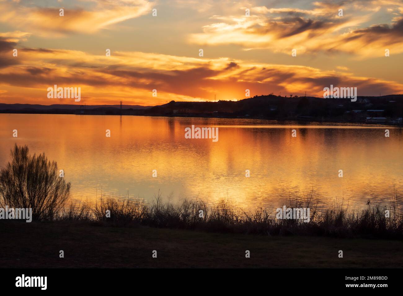 Tramonto su Inks Lake state Park Burnet Texas, USA. La luce dorata si riflette sul cielo e sull'acqua alla fine di una giornata perfetta. Foto Stock