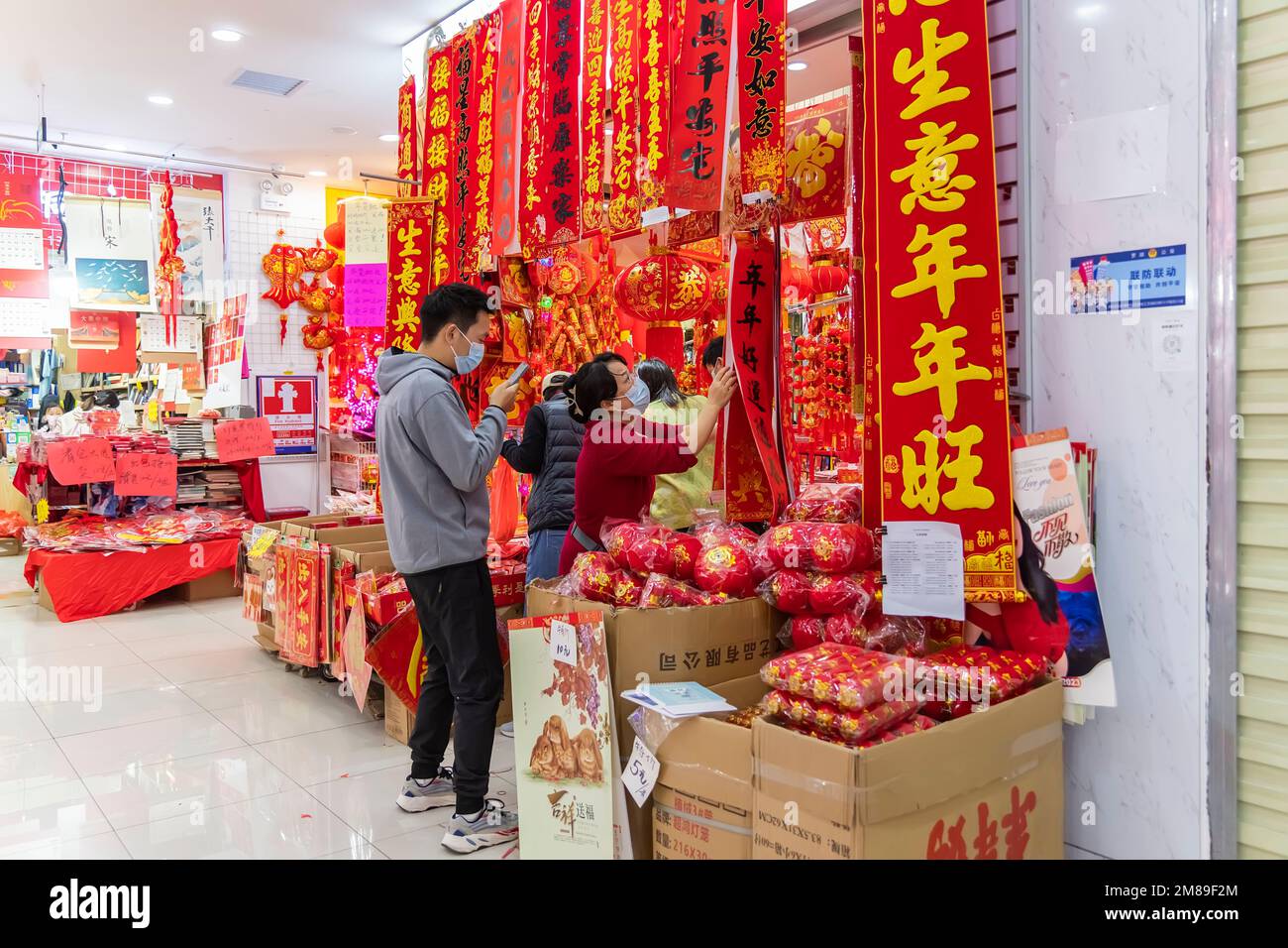 SHEN ZHEN, CINA - Gennaio 9,2023: Gente che acquista tradizione decorazione di cinese e simboli di buona fortuna per il Capodanno cinese nel mercato dei fiori di Shenzhen Foto Stock