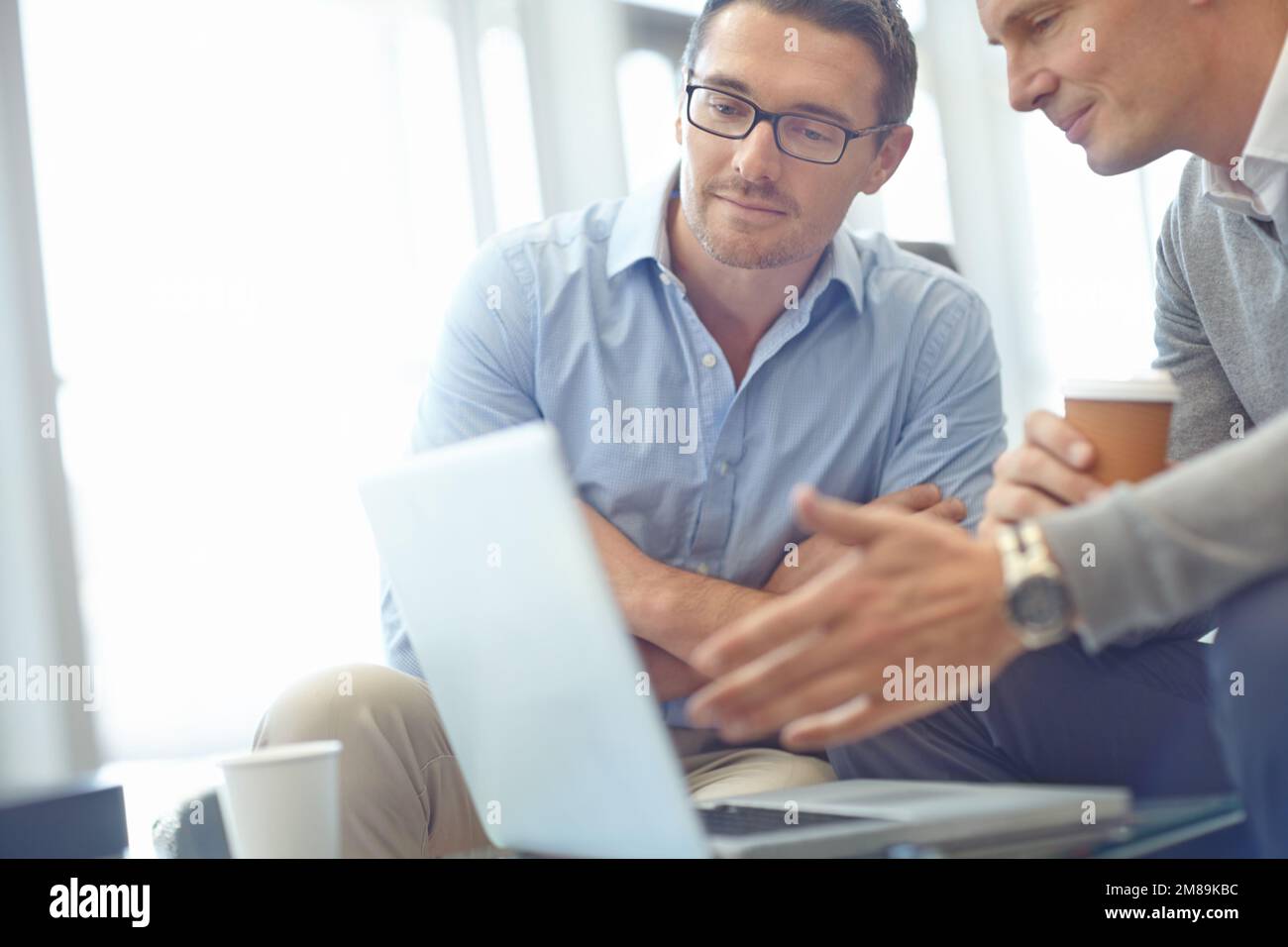 Business man, laptop e strategia di idea in discussione per l'affare, proposta o idea aziendale in ufficio. Persone d'affari che condividono idee, pianificazione del mercato Foto Stock