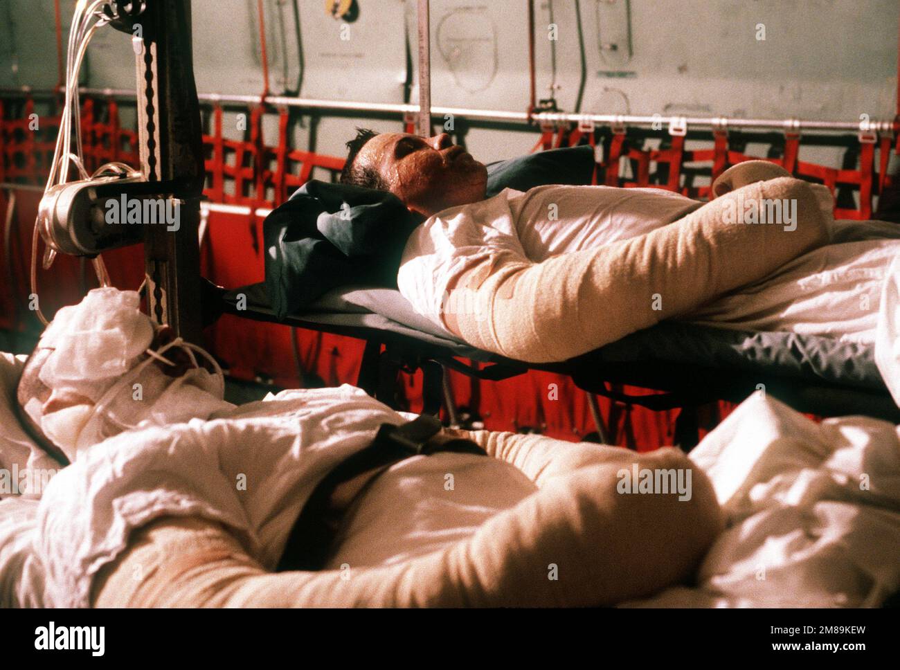 PETTY Officer 3rd Classe David Burbine e MARINAIO apprendista Wayne Smith giacciono su barelle in un aereo militare 438th Airlift Wing C-141b Starlifter che li trasporta in Germania per ulteriori cure mediche. Quattro crewmen furono gravemente feriti quando la fregata missilistica guidata USS SAMUEL B. ROBERTS (FFG-58) colpì una miniera mentre operava nel Golfo Persico. Paese: Sconosciuto Foto Stock