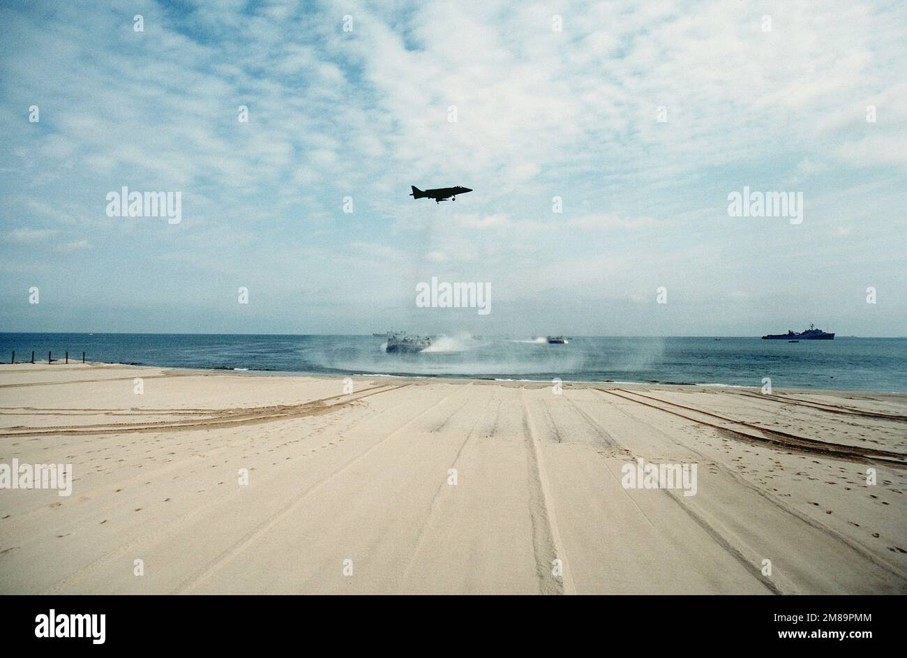 Base navale anfibia. Un aereo AV-8B Harrier vola in alto come nave da sbarco con imbottitura pneumatica Assault Craft Unit 4, dirigendosi verso la riva, dopo essere stato separato dalla nave portuale USS PENSACOLA (LSD-38), a destra, durante una dimostrazione anfibia per la Conferenza navale interamericana del 14th. Base: Naval Amphibious base Stato: Virginia (VA) Paese: Stati Uniti d'America (USA) Foto Stock