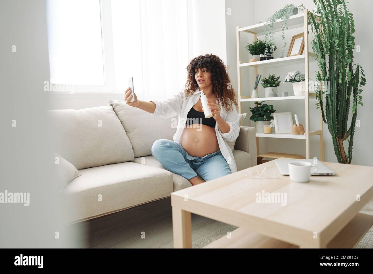 Una donna incinta blogger pubblicizza una crema per le donne incinte da  smagliature sul corpo durante la gravidanza filmare se stessa sul telefono  mentre Foto stock - Alamy