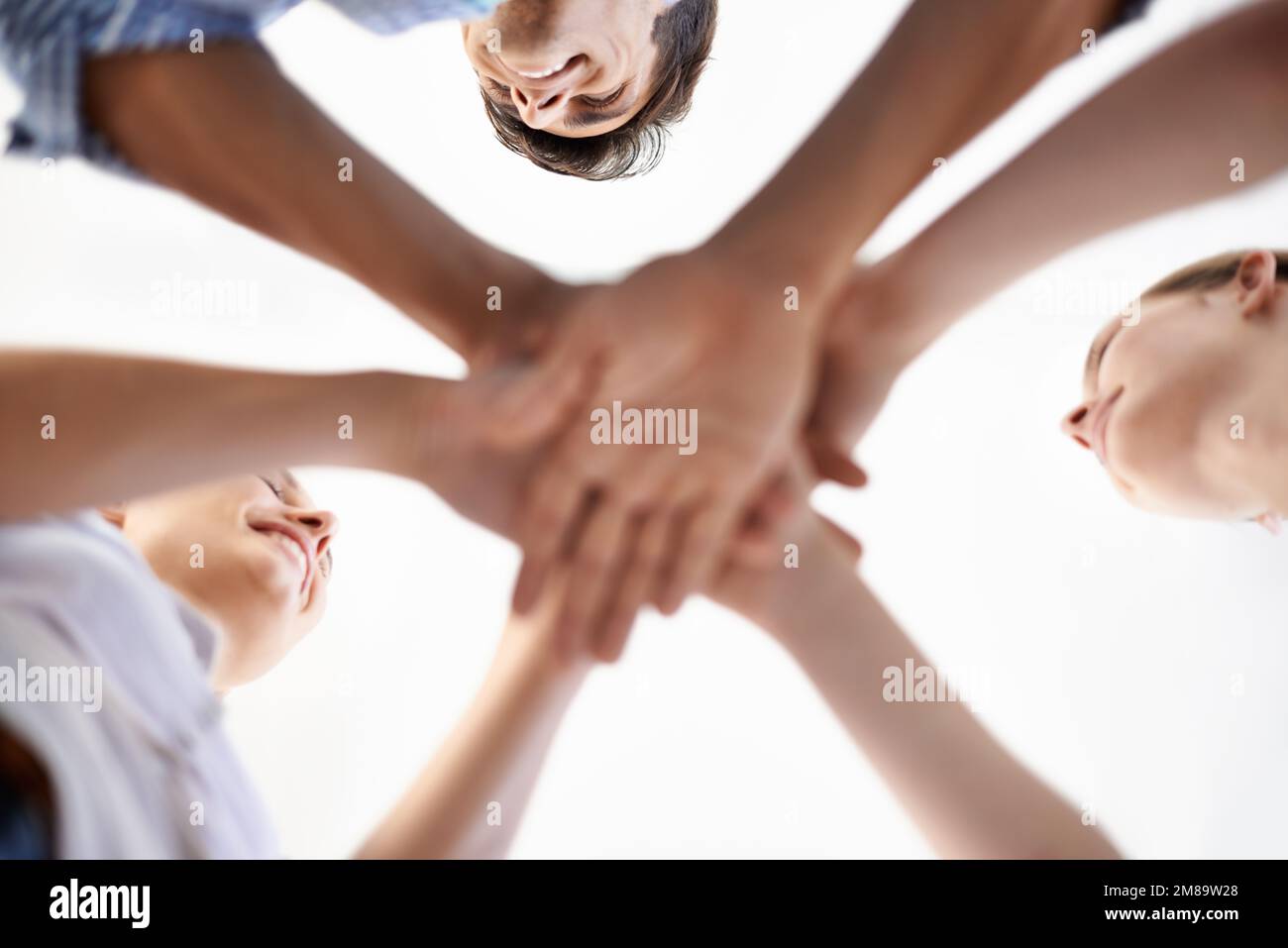 Il lavoro di squadra al suo meglio. Inquadratura a basso angolo dei colleghi che mettono insieme le mani in un gesto di spirito di squadra. Foto Stock