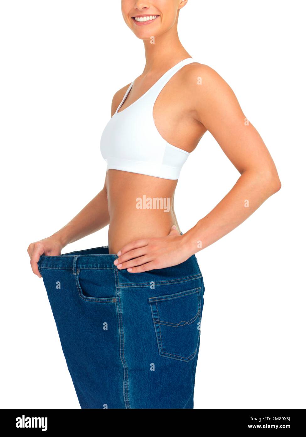 Salute, perdita di peso e donna con jeans e pancia con vita skinny, tagliato e isolato su sfondo bianco. Fitness, salute e benessere Foto Stock