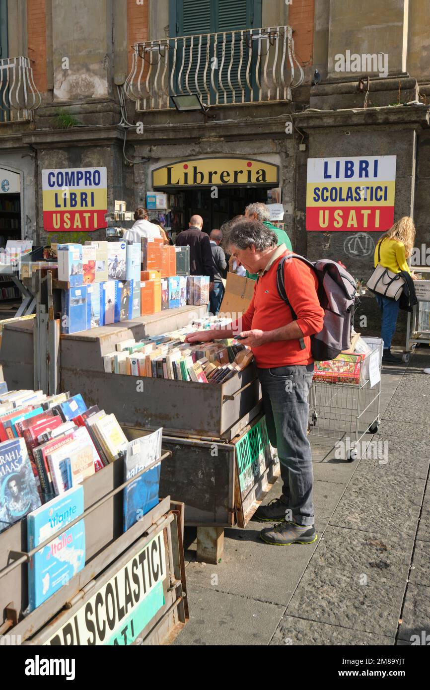 Un uomo acquirente guarda attraverso i bidoni usati in uno dei negozi di Dante piazza. A Napoli, Napoli, Italia, Europa. Foto Stock